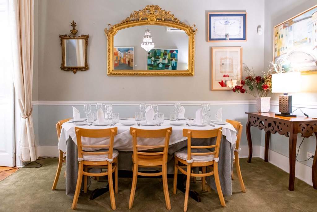 Sala de refeições com mesa preparada e decoração clássica.